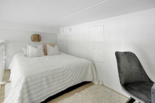 Maple Loft Apartment的白色卧室配有床和椅子