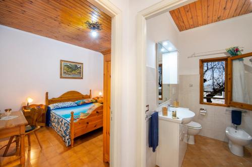 波西塔诺Casa la noce Positano的一间卧室配有一张床,浴室设有水槽