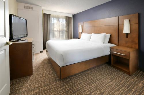 休斯顿休斯敦韦斯特彻斯韦斯特米尔公寓的一间酒店客房,配有一张大床和一台平面电视