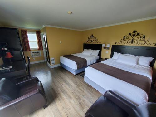 萨默赛德Sunny Isle Motel的酒店客房设有两张床和电视。