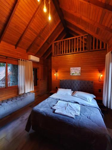 格拉玛多猫头鹰树旅馆的木制客房内的一间卧室配有一张大床
