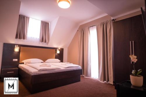 SebeşelMartini Restaurant & Cazare的一间卧室设有一张床和一个大窗户