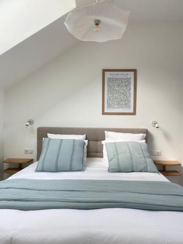 Rilly-la-MontagneLa Cour Tellier的一张带蓝色和白色床单及枕头的床