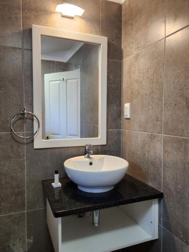 圣卢西亚Hippo Lodge Apartments的浴室设有白色水槽和镜子