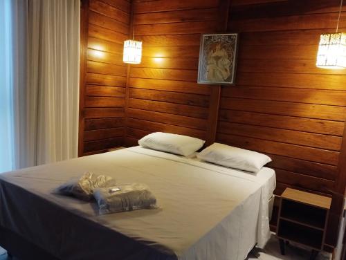 贝洛奥里藏特VIA SPE - Pousada的一间卧室配有一张带木墙和木地板的床。