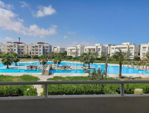 阿莱曼Amwaj North coast chalet in 1st floor families only的享有棕榈树和建筑的游泳池景色