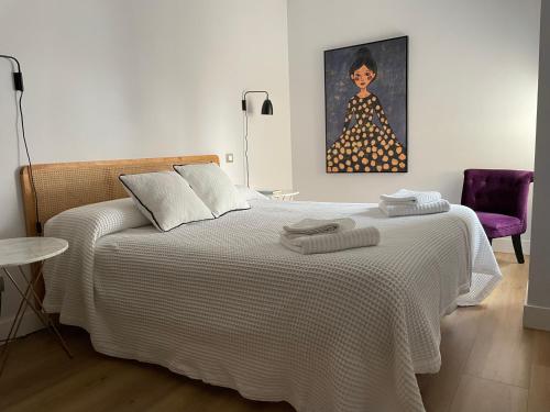 布尔戈斯Contemplando la Catedral by Exclusive Burgos Apartments的卧室配有一张床和一幅女画