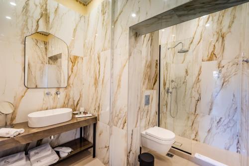 卡瓦拉EPICURE SUITES的浴室配有盥洗盆、卫生间和淋浴。