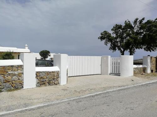 凯勒里瓦迪Blue Waves home Mykonos的街道旁的白色围栏,有树