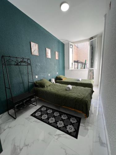 卢尔德Chambre privée Emmanuel Lourdes的一间卧室设有两张床和绿色的墙壁