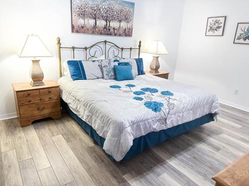 奥兰多Affordable Luxury Home Near Walt Disney World - Sunshine Villa at Glenbrook Resort, Orlando, Florida的一间卧室配有一张带蓝色枕头的床和两盏灯。