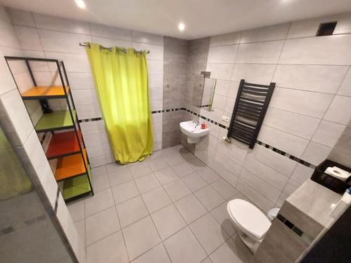 罗兹Galeria kolorów pokój 4 osobowy的浴室设有卫生间和黄色的淋浴帘