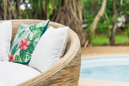 阿维拉纳海滩SoulShine的游泳池畔的带白色枕头的柳条椅