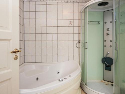 罗莫柯克比Holiday home Rømø XVII的带浴缸和玻璃淋浴间的浴室。