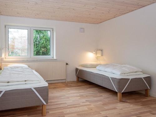 罗莫柯克比Holiday home Rømø XVII的一间卧室设有两张床和窗户。