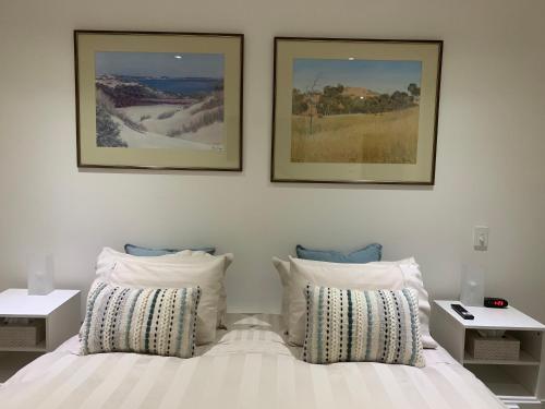 维克多港SEABREEZE at Victor Harbor的卧室配有两张带枕头的床铺上方照片