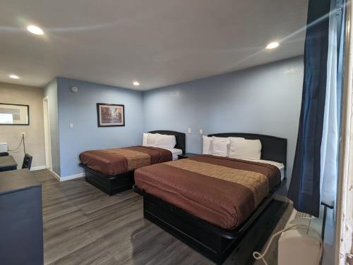 巴斯托BEST MOTEL的两张位于酒店客房的床,拥有蓝色的墙壁