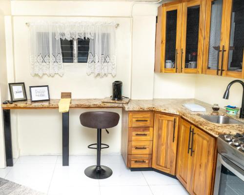 San JuanFrancis Nook Belle Garden Room的厨房配有木制橱柜和凳子