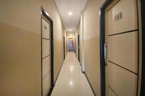 查亚普拉Urbanview Hotel Sabang Land Syariah Jayapura的走廊,有两扇门和一条长长的走廊