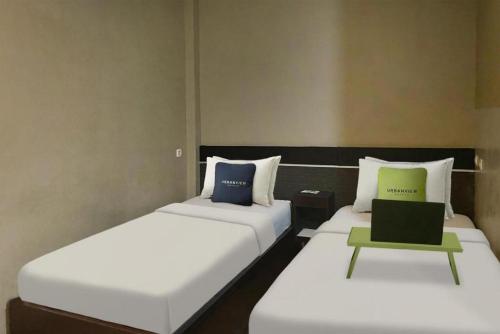查亚普拉Urbanview Hotel Sabang Land Syariah Jayapura的两张睡床彼此相邻,位于一个房间里