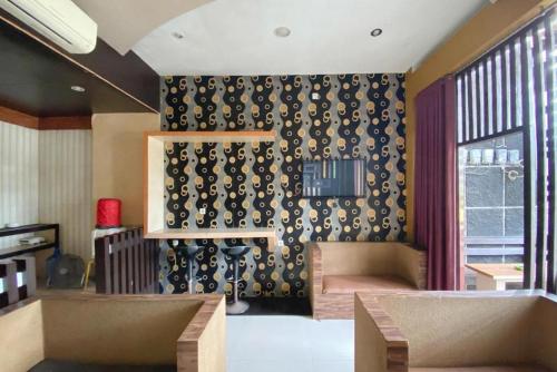 查亚普拉Urbanview Hotel Sabang Land Syariah Jayapura的客厅设有黑白图案的墙壁
