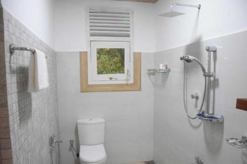 库鲁内格勒Ranathisara Grand Cabanas的一间带卫生间的浴室和墙上的照片