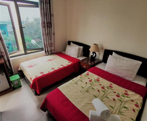 Dien Bien PhuFrontier Hostel & Tours的带窗户的客房内的两张床