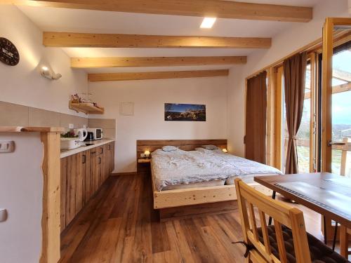 DobravljePanorama glamping Vipavska dolina的一间卧室配有一张床铺和一张桌子,还设有一间厨房