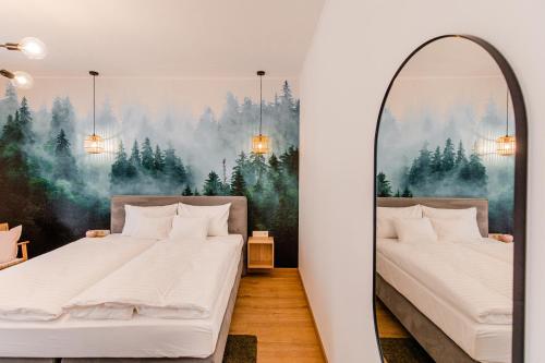 艾斯特根H11 ROOMS ESZTERGOM的配有镜子的客房内的两张床