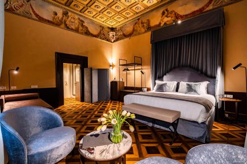 威尼斯Palazzo Keller的酒店客房配有一张床、一张沙发和椅子。
