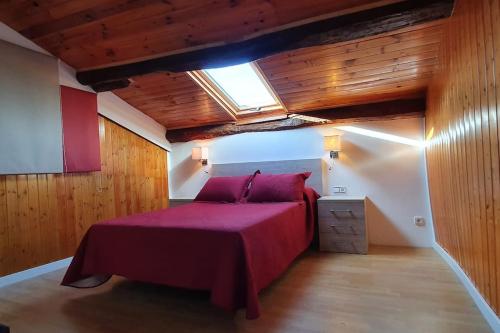 Puigvert de AgramuntCal Curpets - Bicicletas FREE的一间卧室配有一张红色的床和天窗