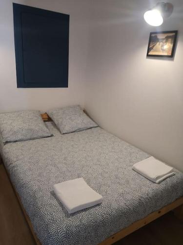 图卢兹Appartement cosy au centre-ville de Toulouse的房间里的一张床位,上面有两条毛巾