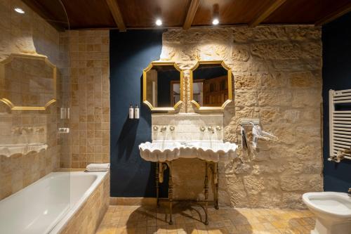 巴埃萨Hotel Cetina Palacio de los Salcedo的带浴缸和盥洗盆的浴室