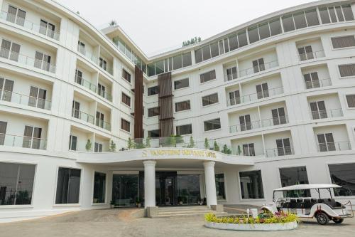 万荣S Vangvieng Boutique Hotel的前面有一辆汽车停放的白色建筑