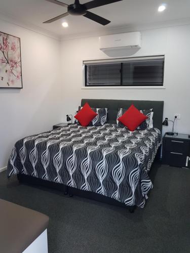 罗马雅典娜一室公寓汽车旅馆的卧室配有黑色和白色的床和红色枕头