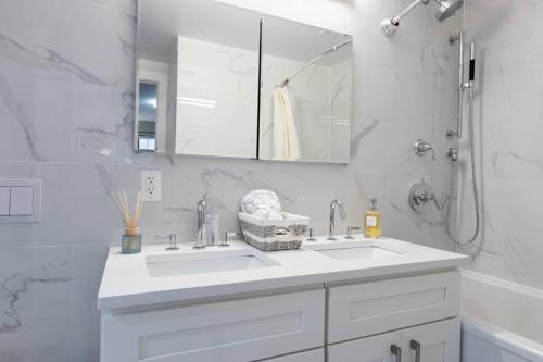 纽约Elegant East Side的白色的浴室设有水槽和镜子