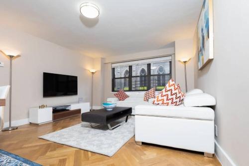 纽约Elegant East Side的客厅配有白色沙发和电视