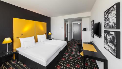 慕尼黑慕尼黑西园假日酒店的酒店客房设有一张大床和一个黄色床头板