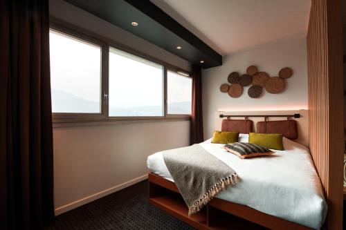 格勒诺布尔COWOOL GRENOBLE的一间卧室设有一张床和两个窗户。