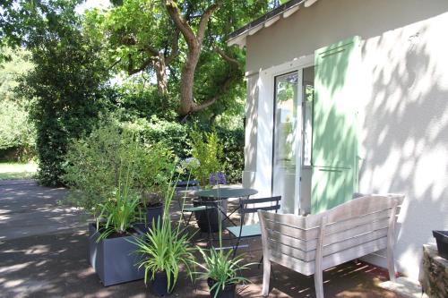 圣纳泽尔La petite chaumine的庭院配有桌椅和植物