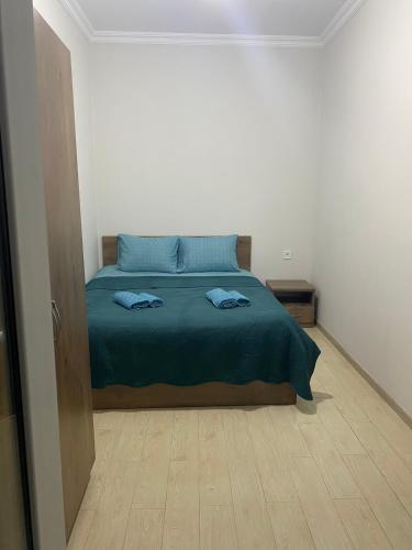 高尼奥All seasons in Gonio beach的一间卧室配有一张蓝色床单,铺有木地板