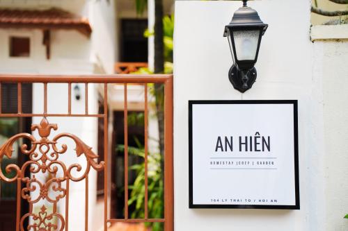会安An Hiên Homestay Hội An的门旁墙上的标牌和灯笼