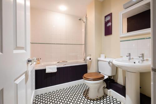 BlythburghWhite Hart Inn的浴室配有卫生间、盥洗盆和浴缸。