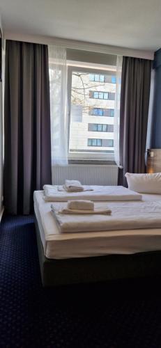 汉堡梅塞德斯中心酒店的配有窗户的酒店客房内的两张床