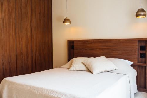拉克鲁瓦瓦尔梅Villa Alemagou的卧室配有白色的床和木制床头板