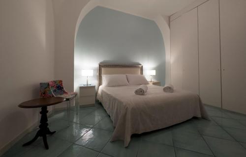 米诺利Amalfi Coast Boutique apartment -sea view - AQUAMARINA的一间卧室配有一张床、一张桌子和两盏灯。