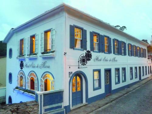 欧鲁普雷图索拉尔玛丽亚酒店的蓝色和白色的建筑,在街上有窗户