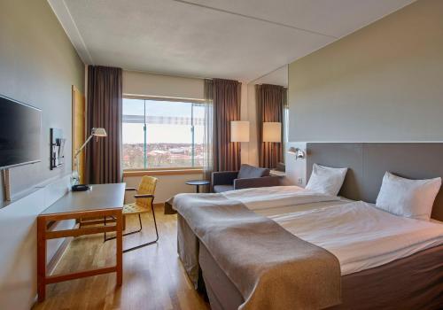 斯德哥尔摩斯堪塔克酒店的酒店客房设有一张大床和一张书桌。