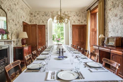 纽基Finest Retreats - Tresillian House的长长的用餐室配有长桌子和椅子