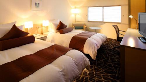 新泻新泻皇冠假日酒店&度假村的酒店客房设有两张床和电视。